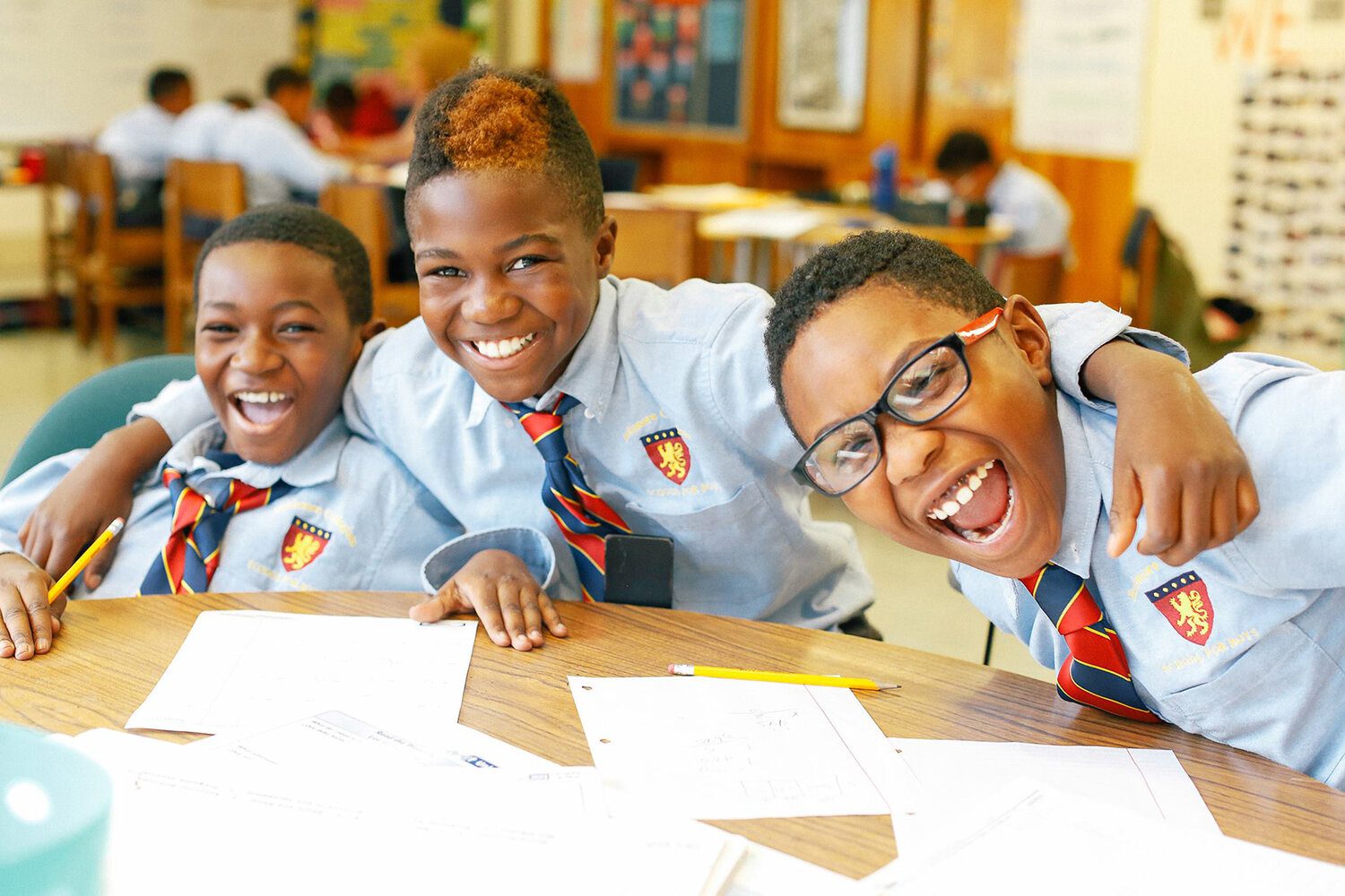 Three boys smiling in the class